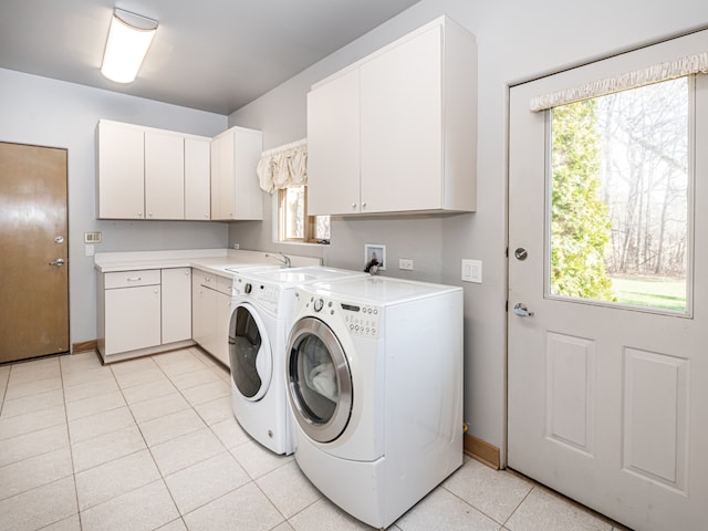 laundry area with a healthy amount of sunlight, light tile patterned floors, cabinets, and washer and dryer