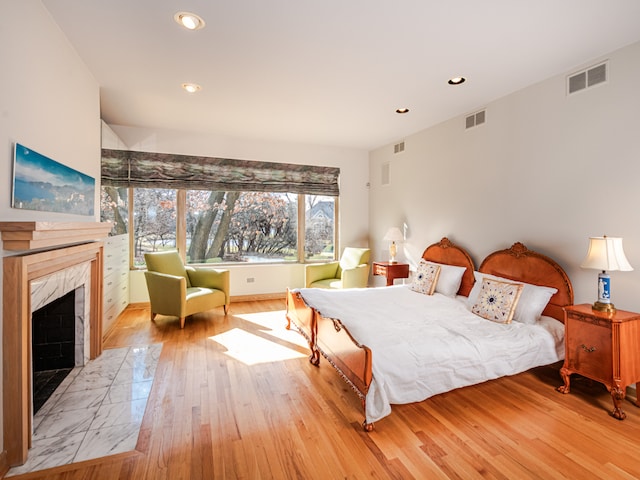 bedroom featuring a fireplace and light hardwood / wood-style floors