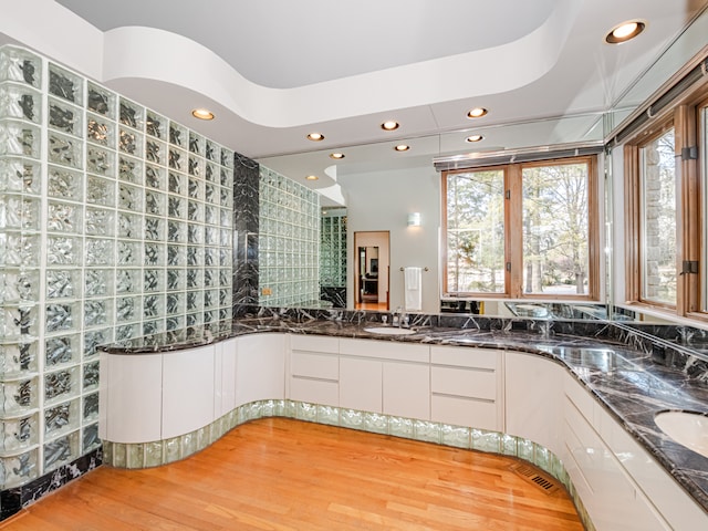 bathroom with vanity, a raised ceiling, and wood-type flooring