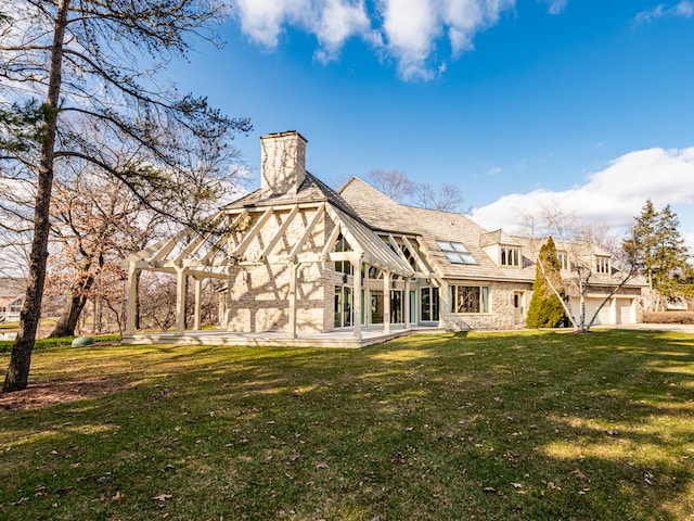 rear view of house featuring a garage, a pergola, and a lawn