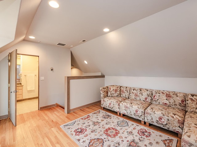 living room featuring light hardwood / wood-style floors and vaulted ceiling