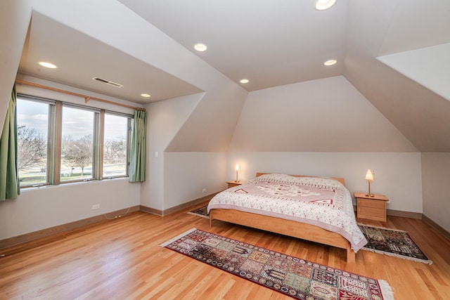 bedroom featuring light wood-type flooring and vaulted ceiling