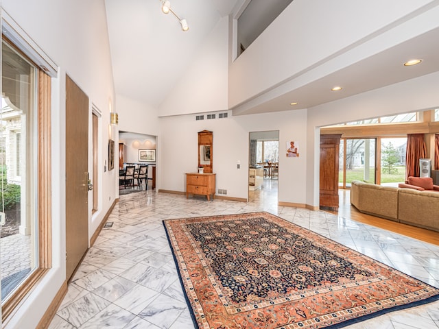 tiled foyer entrance featuring high vaulted ceiling