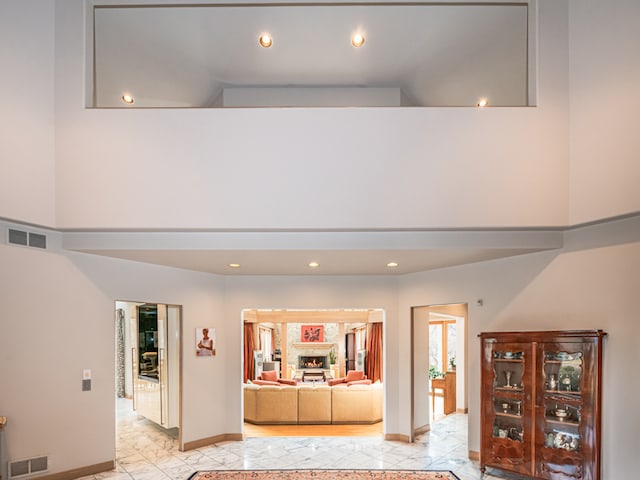 unfurnished living room featuring a towering ceiling