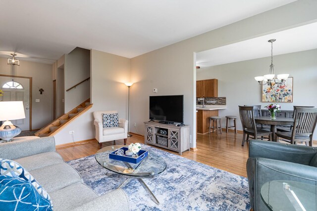 19154 Crescent Dr, Mokena, IL 60448 - living room featuring light wood-style floors, stairway, and a chandelier