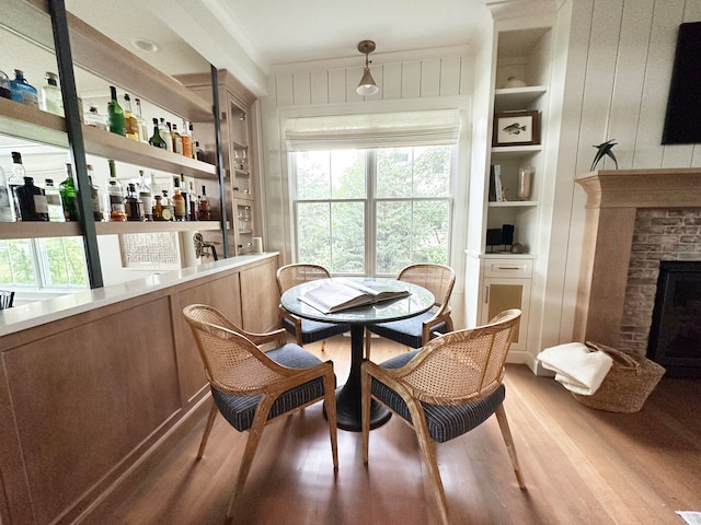 dining room featuring built in features, bar, and light hardwood / wood-style floors