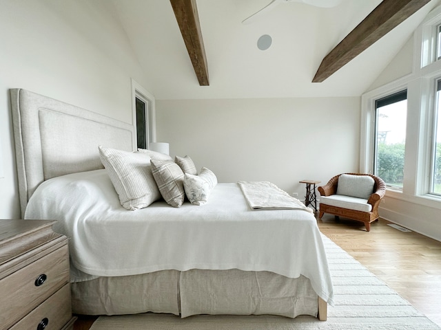 bedroom with ceiling fan, vaulted ceiling with beams, and light wood-type flooring