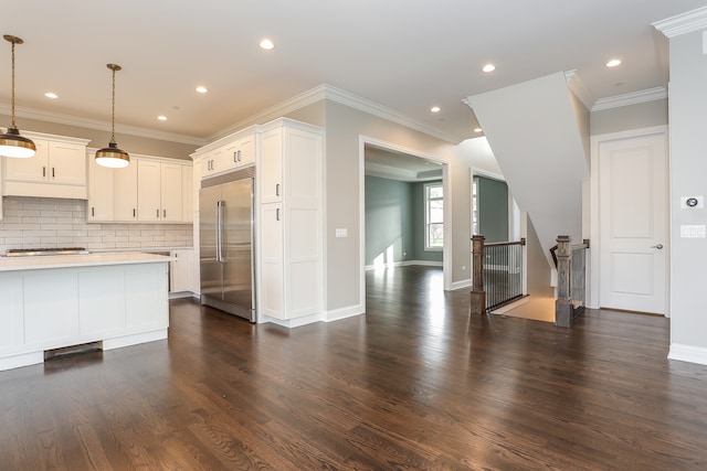 kitchen with appliances with stainless steel finishes, dark wood-type flooring, and decorative light fixtures