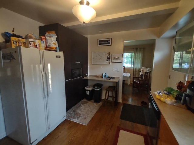 kitchen with white refrigerator and dark hardwood / wood-style flooring