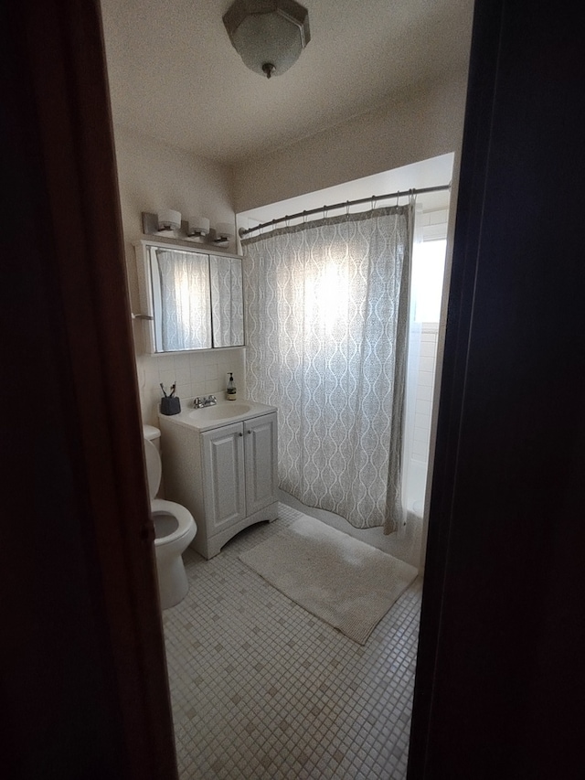 bathroom with vanity, toilet, and curtained shower