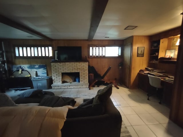 living room featuring light tile patterned flooring, a fireplace, and wooden walls