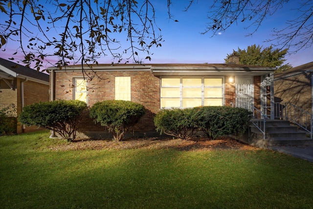 property exterior at dusk with a lawn