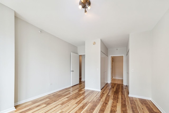 unfurnished bedroom featuring a closet and light hardwood / wood-style floors