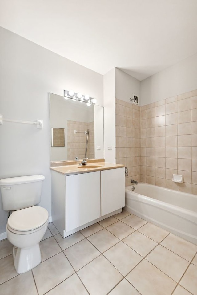 full bathroom featuring toilet, tile flooring, tiled shower / bath combo, and vanity