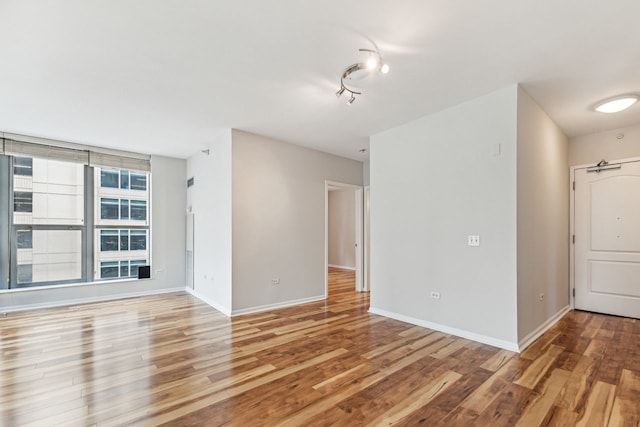 unfurnished room with light wood-type flooring and track lighting