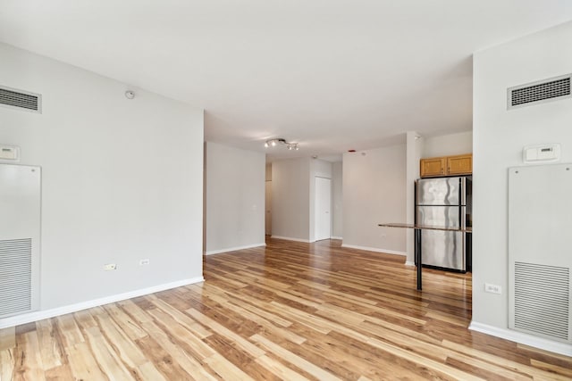 spare room with track lighting and light hardwood / wood-style floors