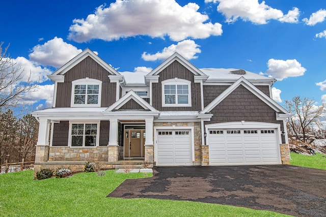 craftsman-style house with a front yard, a porch, and a garage