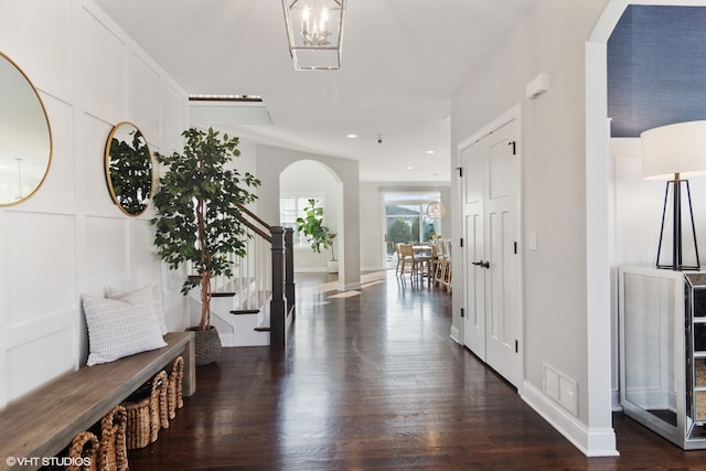 hallway featuring a chandelier and dark wood-type flooring