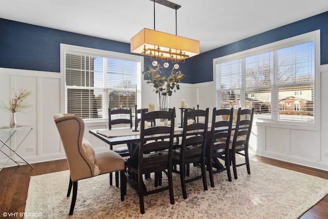 dining area with dark hardwood / wood-style floors, a healthy amount of sunlight, and a notable chandelier