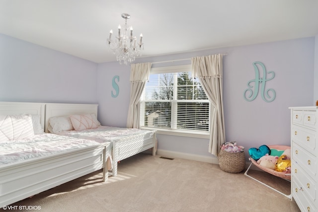 carpeted bedroom featuring an inviting chandelier