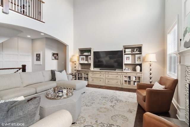 living room featuring a towering ceiling and hardwood / wood-style flooring