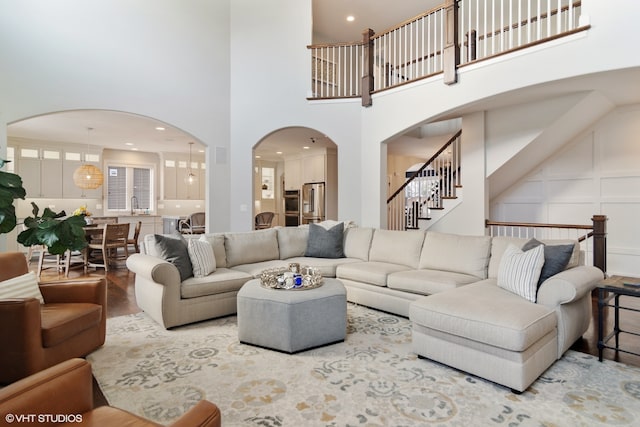 living room with hardwood / wood-style floors and a towering ceiling