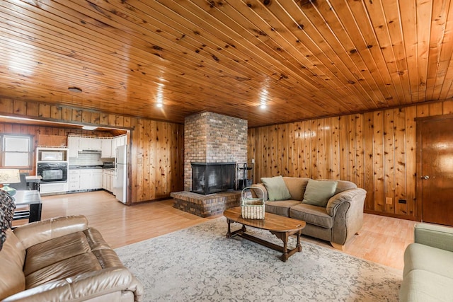 living area featuring wooden ceiling, light wood-style floors, a fireplace, and wood walls