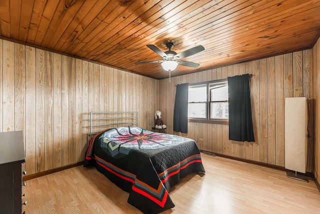 bedroom with wooden ceiling, wooden walls, baseboards, and wood finished floors