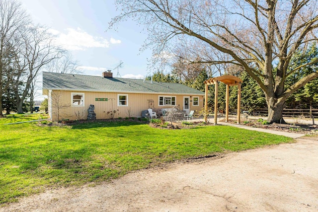 back of house featuring a patio, a chimney, dirt driveway, a lawn, and fence