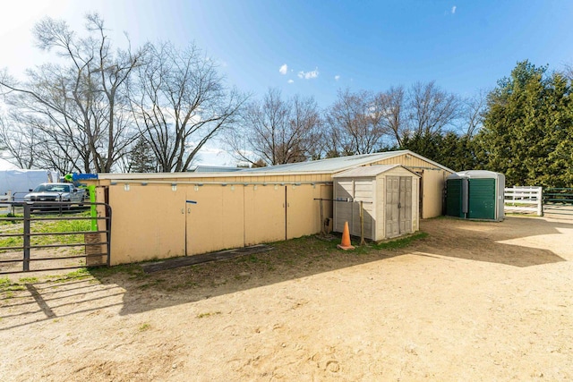 view of shed featuring fence and a gate