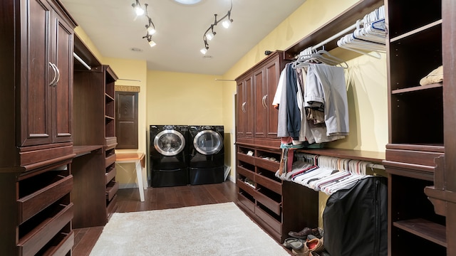 walk in closet with separate washer and dryer and dark wood-type flooring