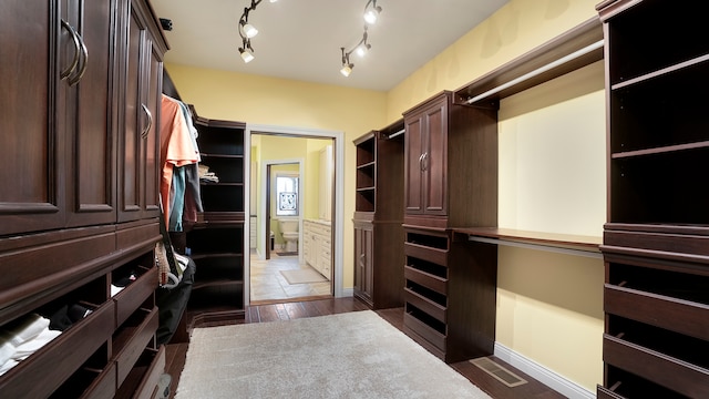 spacious closet featuring dark tile flooring