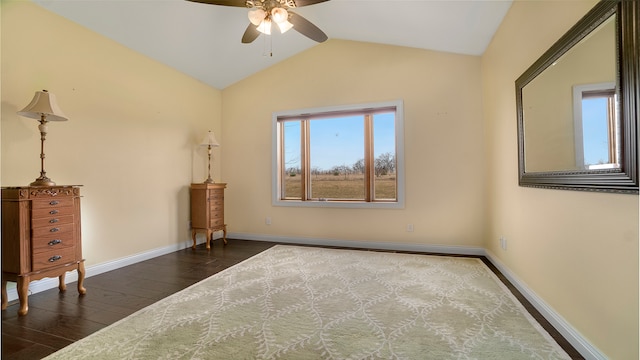 empty room with ceiling fan, dark wood-type flooring, and vaulted ceiling