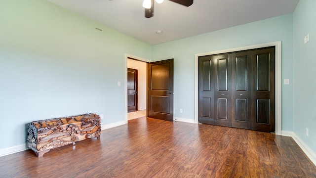 interior space with ceiling fan, a closet, and dark wood-type flooring