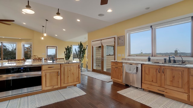 kitchen featuring hardwood / wood-style floors, ceiling fan, appliances with stainless steel finishes, sink, and pendant lighting