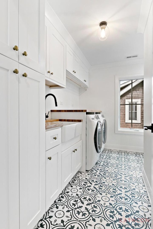 laundry area featuring cabinets, sink, washing machine and dryer, and light tile flooring