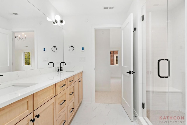 bathroom featuring large vanity, dual sinks, a chandelier, an enclosed shower, and tile floors