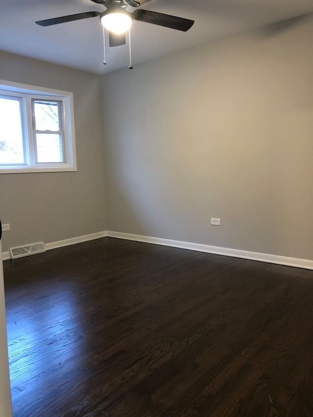 unfurnished room featuring ceiling fan and dark wood-type flooring