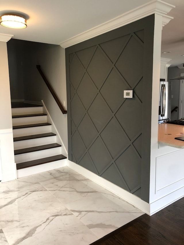 stairway with crown molding and wood-type flooring