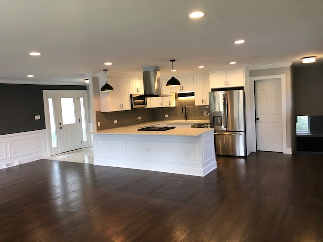 kitchen with appliances with stainless steel finishes, dark hardwood / wood-style flooring, white cabinets, hanging light fixtures, and sink