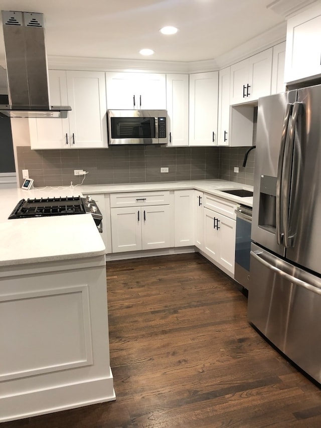 kitchen featuring white cabinetry, backsplash, appliances with stainless steel finishes, dark hardwood / wood-style flooring, and exhaust hood