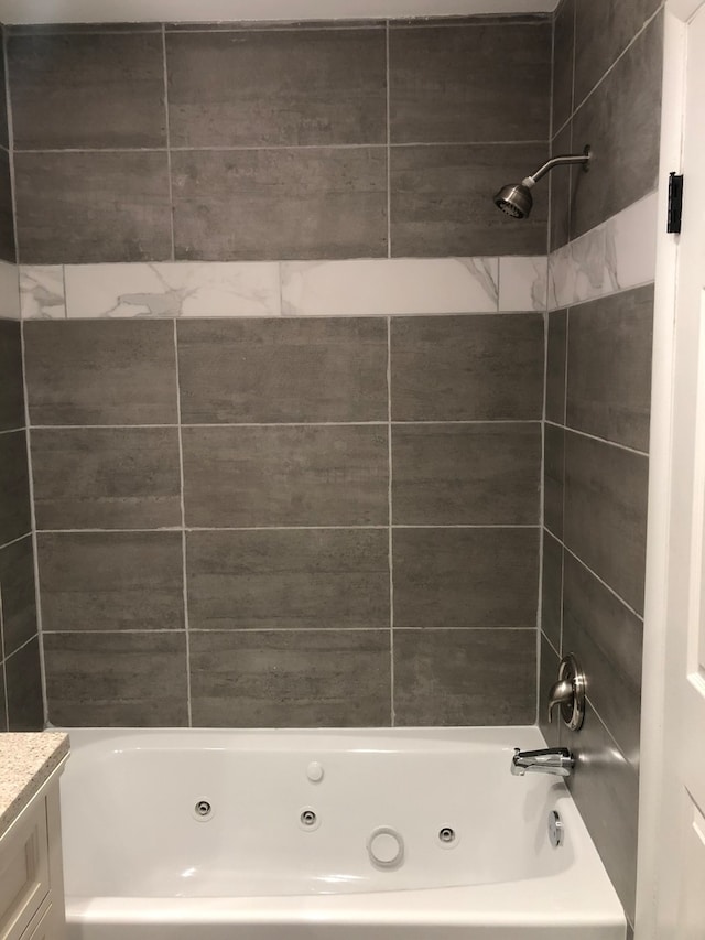 bathroom featuring vanity and tiled shower / bath