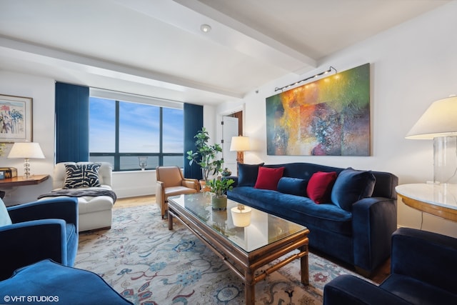 living room with light wood-type flooring, a water view, and beamed ceiling