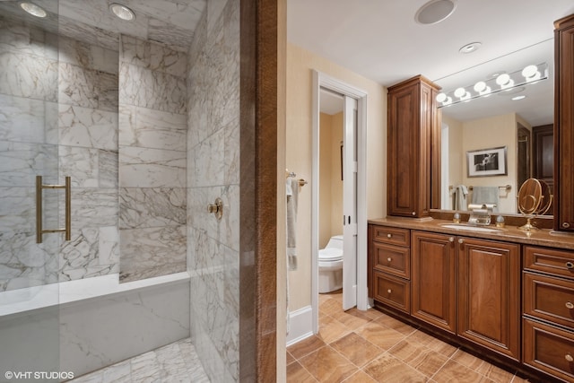 bathroom with toilet, a shower with door, tile flooring, and vanity