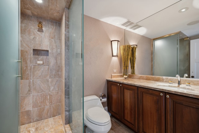 bathroom featuring a shower with shower door, tile flooring, toilet, and vanity