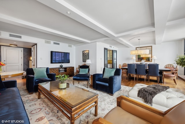 living room featuring coffered ceiling, light wood-type flooring, and beam ceiling