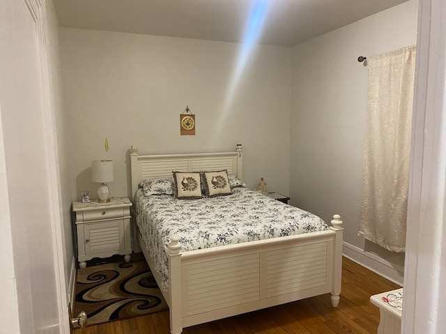 bedroom with dark wood-type flooring