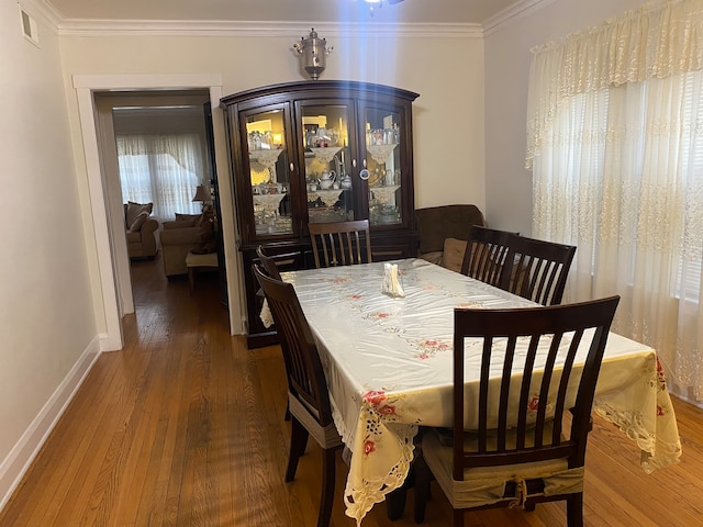 dining room with crown molding and dark hardwood / wood-style floors