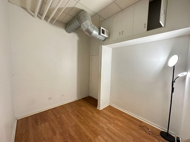 unfurnished room featuring light hardwood / wood-style flooring and a drop ceiling