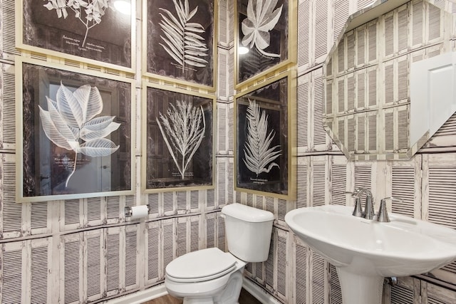 bathroom featuring toilet and tile walls